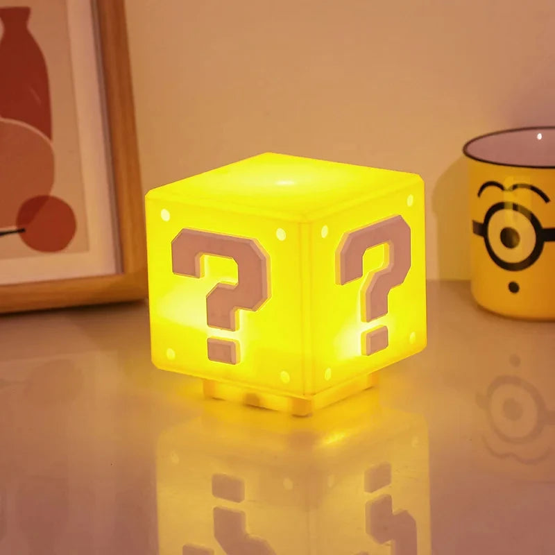 Mario box with question marks on a table next to a Minion mug